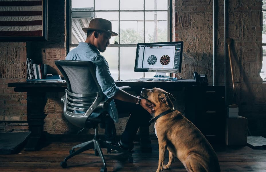 photograph of a man and his dog by a computer