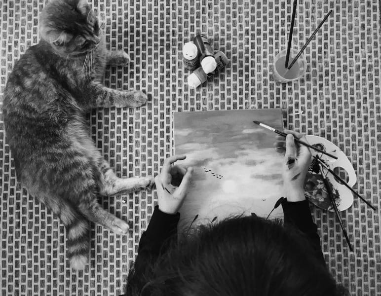 Image of an artist painting a cat